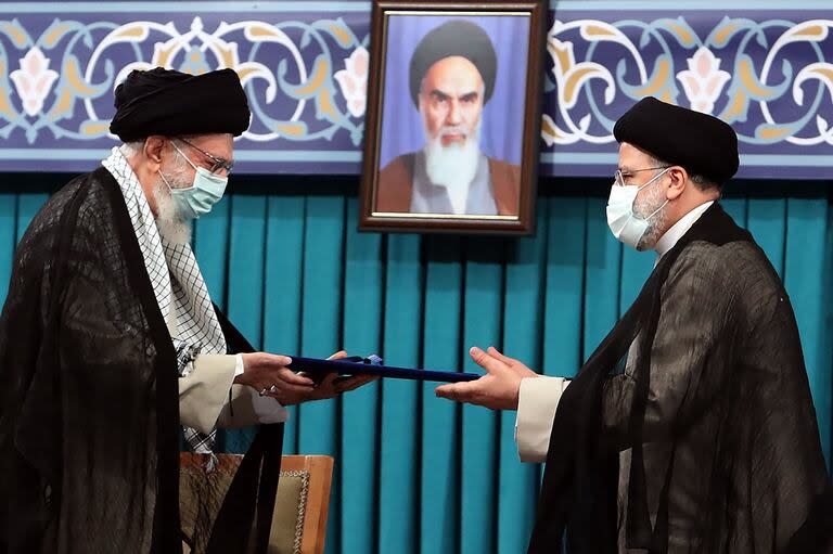 Una fotografía proporcionada por la oficina del líder supremo de Irán, el ayatolá Ali Khamenei, el 3 de agosto de 2021, lo muestra (izq.) durante la ceremonia de toma de posesión de Ebrahim Raisi (derecha) como presidente, en la oficina de Khamenei en la capital, Teherán.