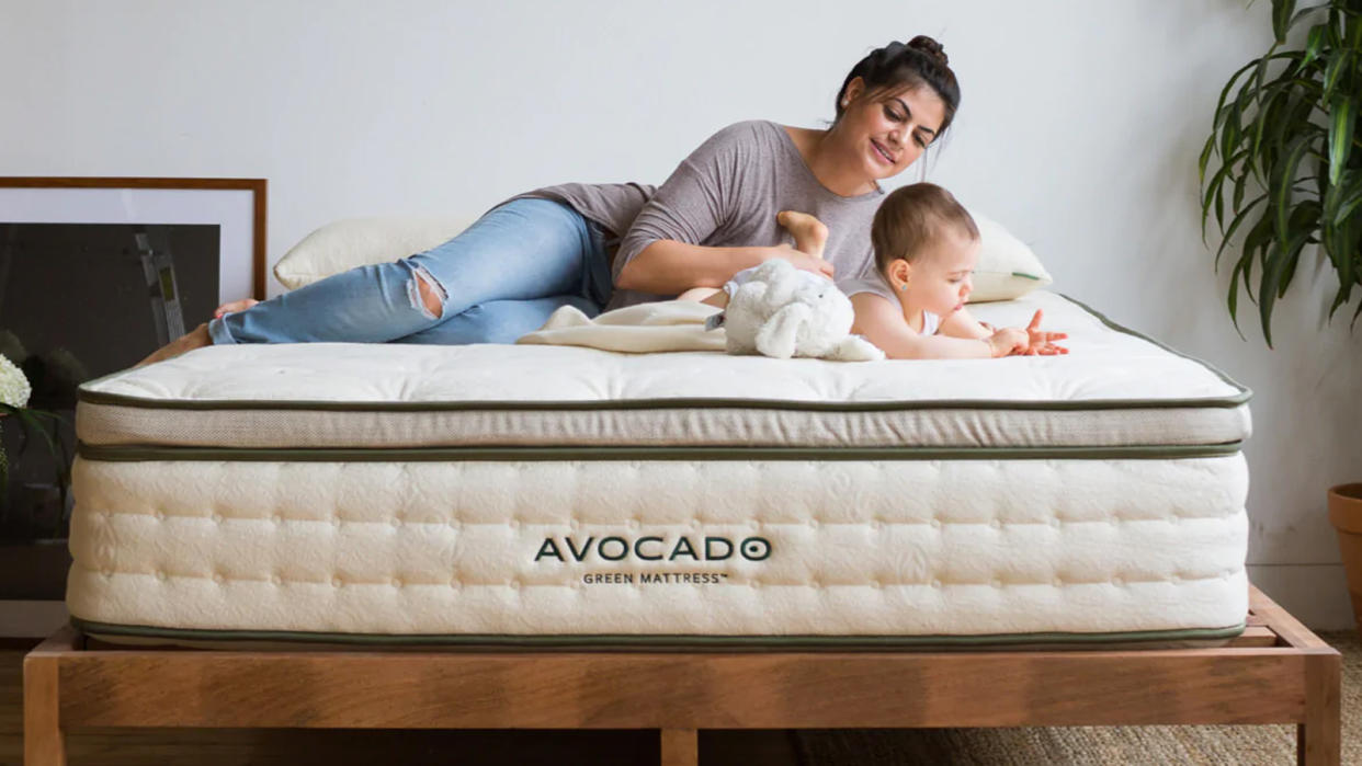  Avocado Green Mattress review image shows a woman and a baby lying on top. 