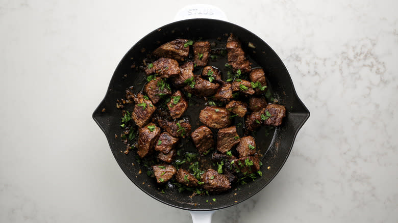 steak pieces in frying pan