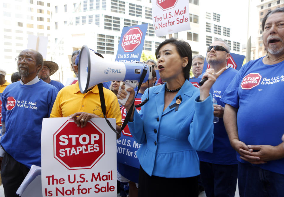 U.S. Congresswoman Judy Chu (D-Calif.) joins U.S. Post Office employees during a protest outside a Staples store, Thursday, April 24, 2014, in downtown Los Angeles. Postal workers around the country protested in front of Staples stores on Thursday, objecting to the U.S. Postal Service's pilot program to open counters in stores, staffed with retail employees. (AP Photo/Damian Dovarganes)