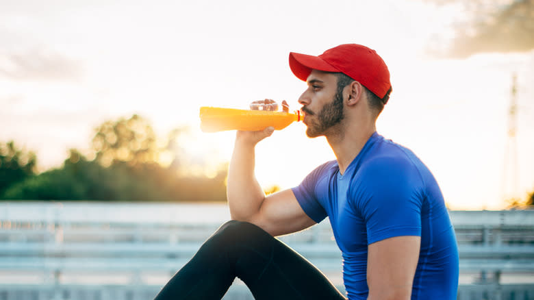 Man Drinking Sports Drink Sunset