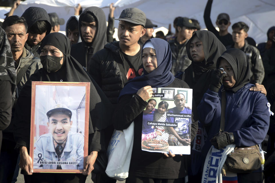 Family of victims holds pictures of those who died tragically in the October 2022 stampede at the Kanjuruhan stadium in Malang, Indonesia, commemorating one-year anniversary of the deadly incident in Malang, East Java province, Indonesia, Sunday, Oct 1, 2023. The crowd surge was among the world's worst sporting tragedies. Some 43 children died and around 580 people were injured in the incident. (AP Photo/Hendra Permana)