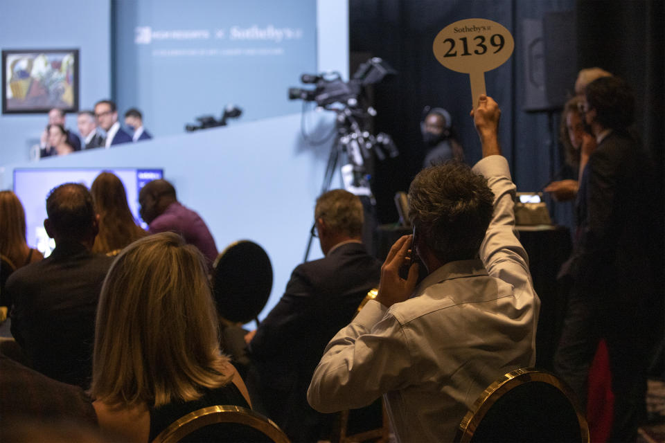 A buyer places a bid during an auction of Pablo Picasso's master works at the Bellagio hotel and casino Saturday, Oct. 23, 2021, in Las Vegas. Sotheby's and the MGM Resorts Fine Art Collection hosted the auction, which raised $109 million from eleven pieces. (AP Photo/Ellen Schmidt)