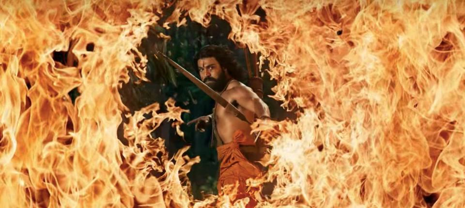 Ram Charan with a bow and arrow surrounded by fire
