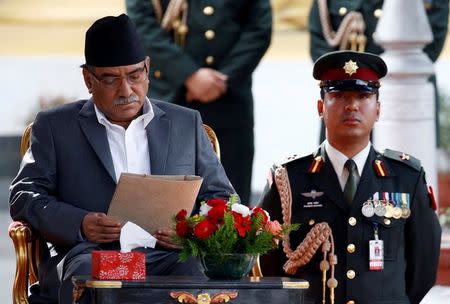 Newly elected Nepalese Prime Minister Pushpa Kamal Dahal, also known as Prachanda, (L) reads the oath paper upon his arrival to administers the oath of office at the presidential building "Shital Niwas" in Kathmandu, Nepal, August 4, 2016. REUTERS/Navesh Chitrakar