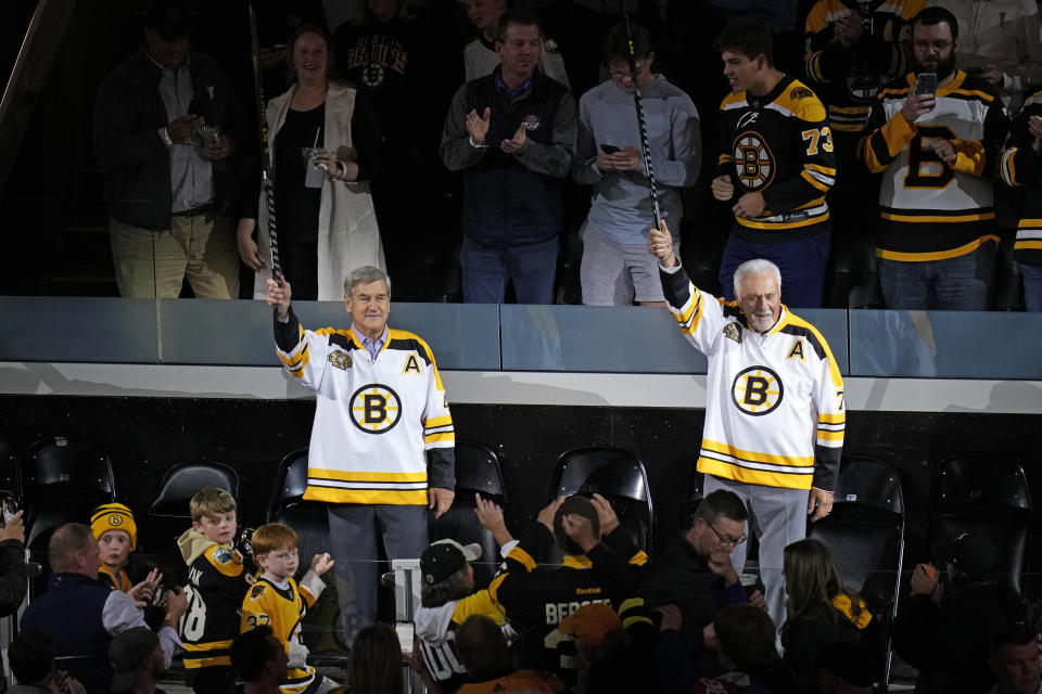 Boston Bruins greats Bobby Orr, left, and Phil Esposito raise sticks in celebration of the 100th year of the NHL hockey team, prior to a game between the Bruins and Chicago Blackhawks, Wednesday, Oct. 11, 2023, in Boston. (AP Photo/Charles Krupa)