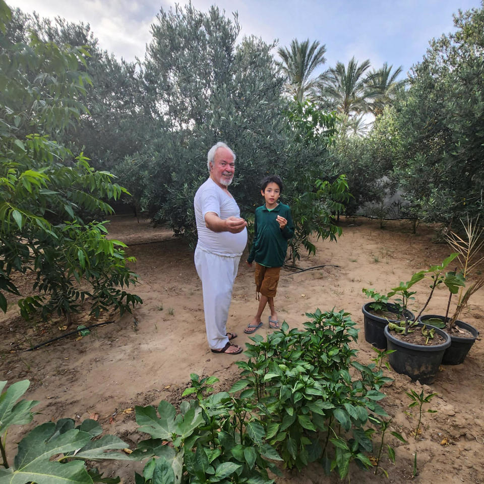 Hamed Alhayek shows his grandson Khaled Alhayek parts of their garden in their home in Gaza City's 