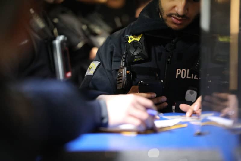 A police officer stands at the counter during a search of a gambling hall. Police, customs, the public order office and the tax investigation department jointly searched premises in Duisburg under suspicion of illegal gambling under the watchful eye of NRW Interior Minister Reul. -/dpa