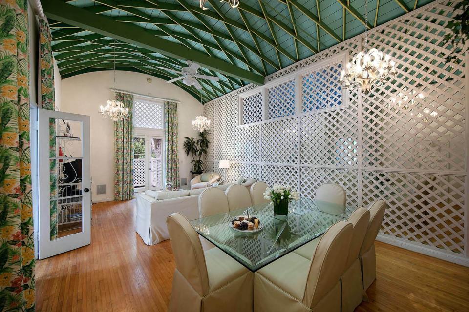 a formal table and seating area in a room with white walls and a green ceiling