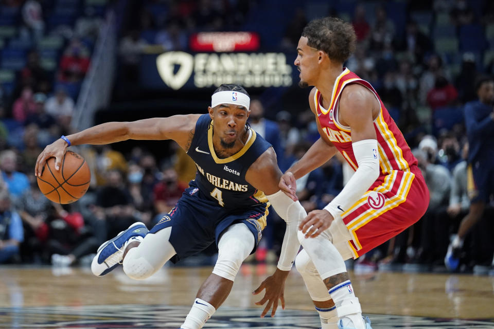 New Orleans Pelicans guard Devonte' Graham (4) drives to the basket against Atlanta Hawks guard Trae Young in the second half of an NBA basketball game in New Orleans, Wednesday, Oct. 27, 2021. The Hawks won 102-99. (AP Photo/Gerald Herbert)