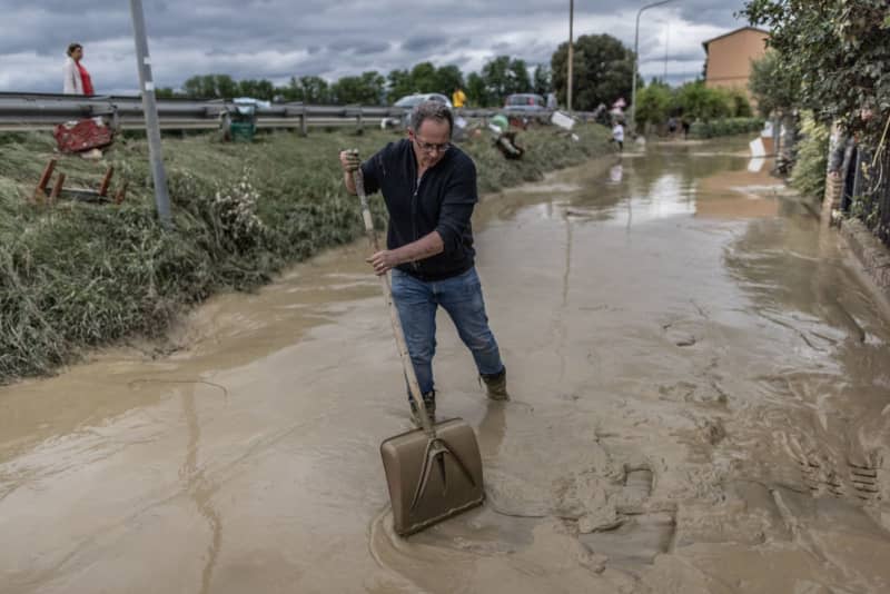 A local resident tries to clean a street from mud and water following floods. Climate change is exacerbating floods and droughts and reducing water quality, posing an increasing threat to people's health, according to a report published by the European Environment Agency (EEA) on Wednesday. Oliver Weiken/dpa