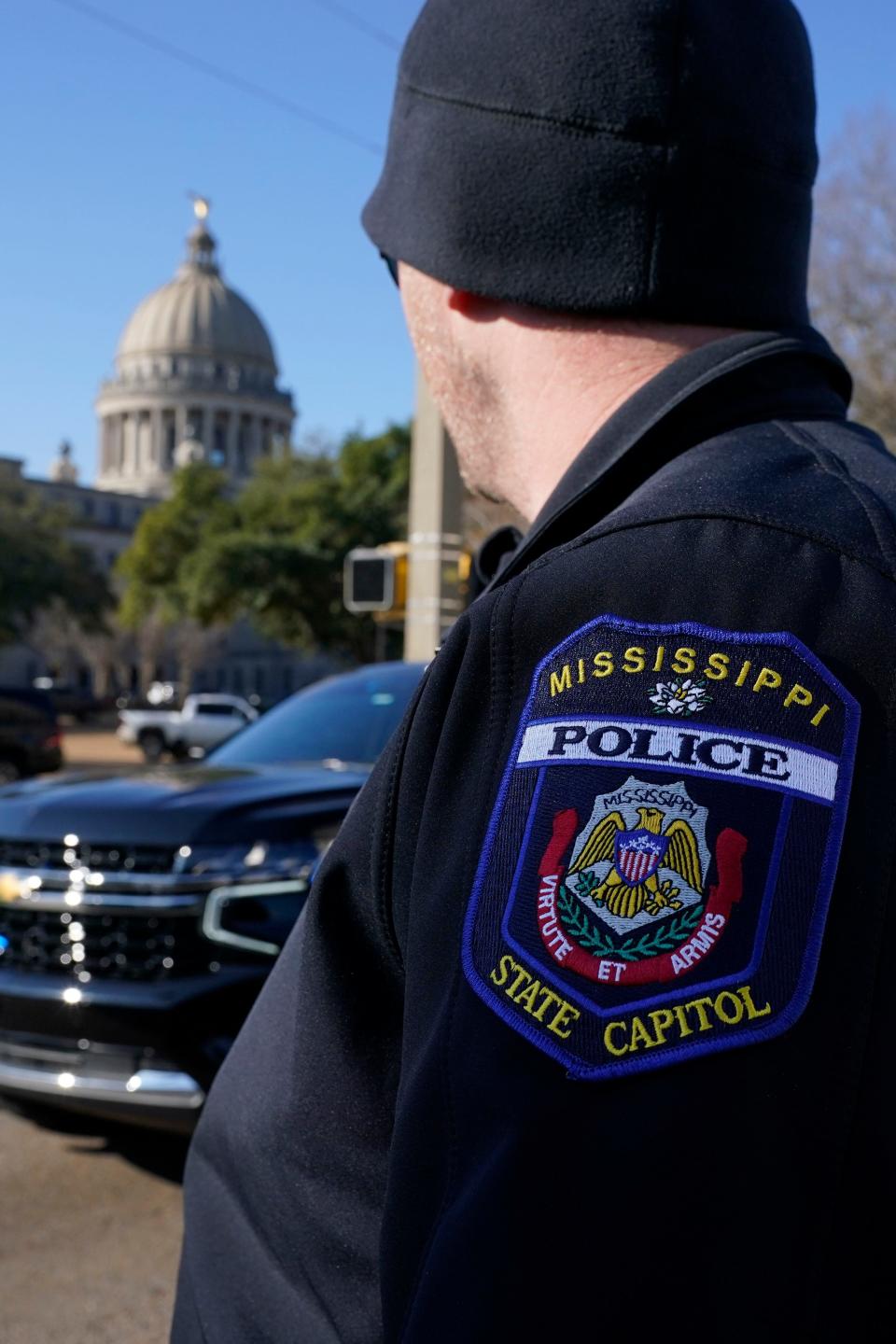 A Capitol Police officer stares at the dome of the Mississippi State Capitol in Jackson, Miss., Thursday, Jan. 4, 2024, as they deal with a second consecutive day of bomb threats to the state house and to the Carroll Gartin Justice Building, which houses the state supreme and appellate courts.