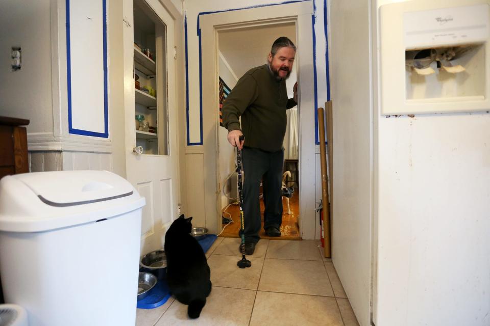 Benjamin Brighton uses a cane to walk around his Somersworth home.