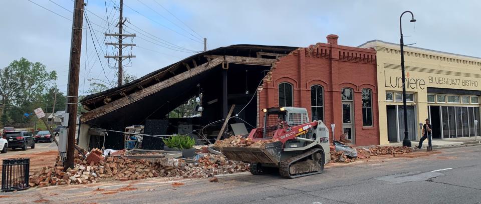 Workers clear debris Oct. 1 from a building on Main Street in downtown Houma wrecked by Hurricane Ida. The restaurant next door has reopened.
