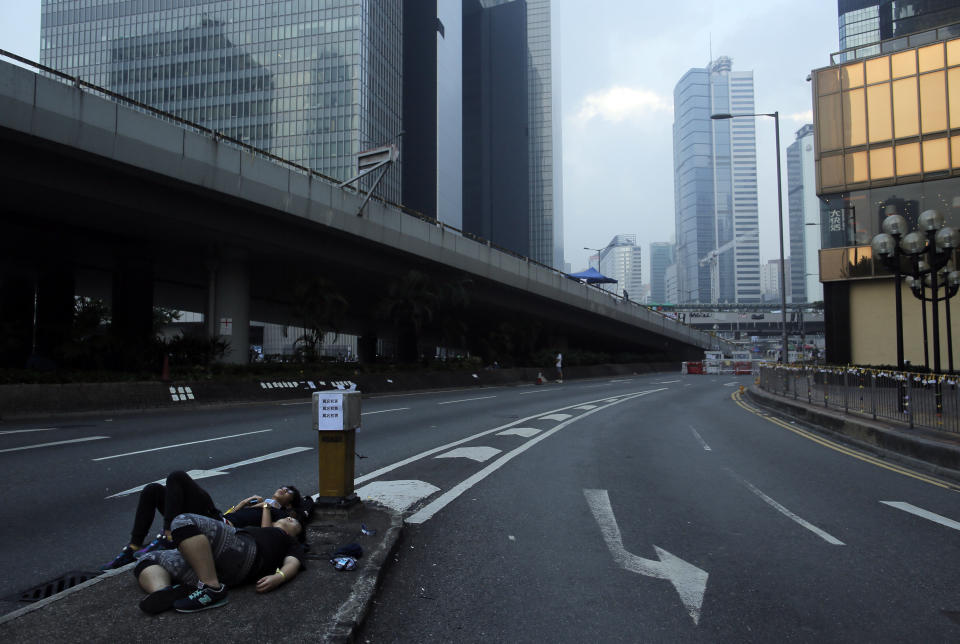 Protesters sleep in a main road as they block the road at the financial district in Hong Kong, Friday, Oct. 3, 2014. (AP Photo/Vincent Yu)