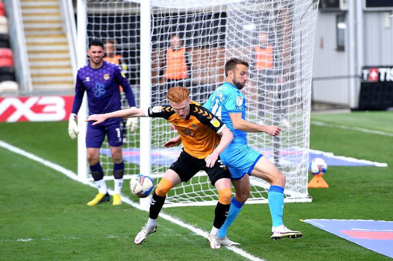 Newport County's Ryan Haynes (left) and Cheltenham Town's Andy Williams battle for the ball