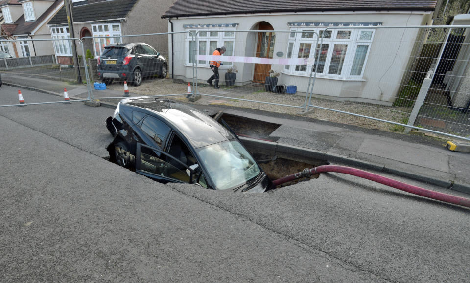 A Toyota car in a sinkhole which appeared overnight in Hatch Road, Brentwood, in the aftermath of Storm Ciara, which hit the country Sunday.