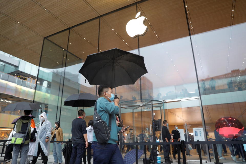 People wearing face masks are pictured at an Apple Store on the day the new Apple iPhone 13 series goes on sale, in Beijing, China, September 24, 2021. REUTERS/Carlos Garcia Rawlins - RC22WP99PAE2