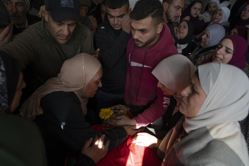 Mourners take the last look at the body of Palestinian Abdel Rahman Hamed, 18 during his funeral in the West Bank town of Silwad Monday, Jan. 29, 2024. Palestinian authorities say five Palestinians have been killed by Israeli forces in separate shootings across the occupied West Bank on Monday including Hamed who was killed during clashes with Israeli border police at his home village of Silwad. (AP Photo/Nasser Nasser)