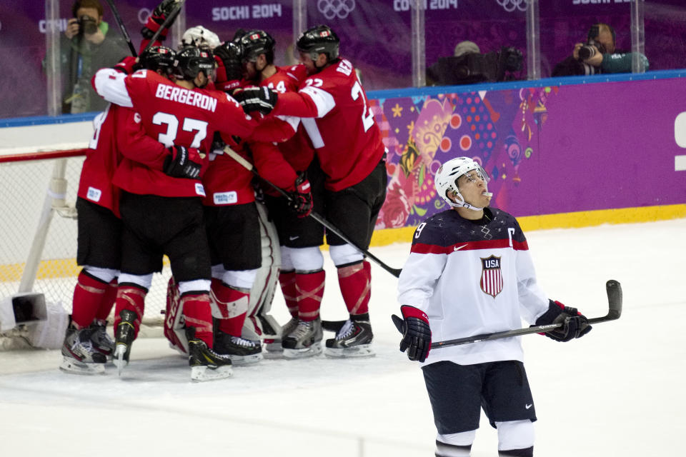 USA forward Zach Parise looks up at the scoreboard as Canada celebrates their 1-0 victory in men's semifinal ice hockey game at the 2014 Winter Olympics, Friday, Feb. 21, 2014, in Sochi, Russia. (AP Photo/J. David Ake)