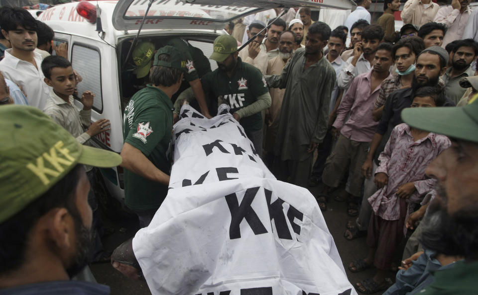 Pakistani rescue workers load a dead body into an ambulance after recovering from a burnt garment factory in Karachi, Pakistan on Wednesday, Sept. 12, 2012. Pakistani officials said the death toll from devastating factory fires that broke out in two major cities has risen to 128. Hospital official Tariq Kaleem says the fire at a garment factory in the southern Pakistani city of Karachi killed 103 people. A blaze at a shoe factory in the eastern city of Lahore killed 25 people. (AP Photo/Fareed Khan)