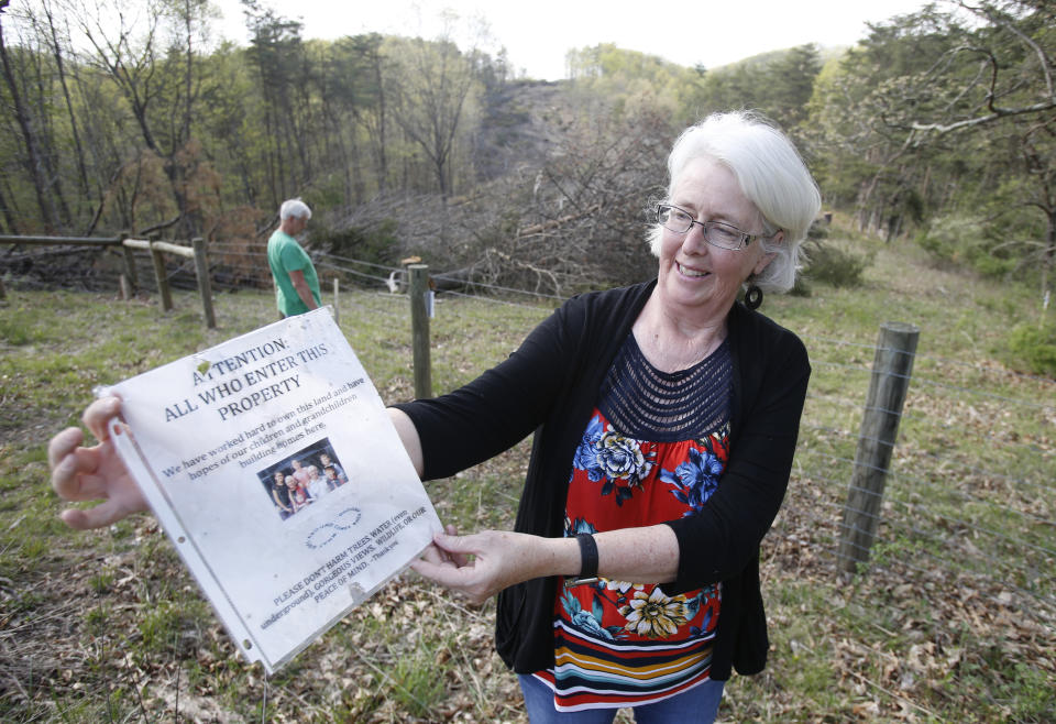 FILE - In this May 3, 2018, file photo, Becky Crabtree displays a flyer that she posted on a fence on the route of the proposed Mountain Valley pipeline on their property in Lindside, W.Va. A Virginia-based legal group is asking the U.S. Supreme Court to end what it says has become an abuse of eminent domain by companies that build natural-gas pipelines. (AP Photo/Steve Helber, File)