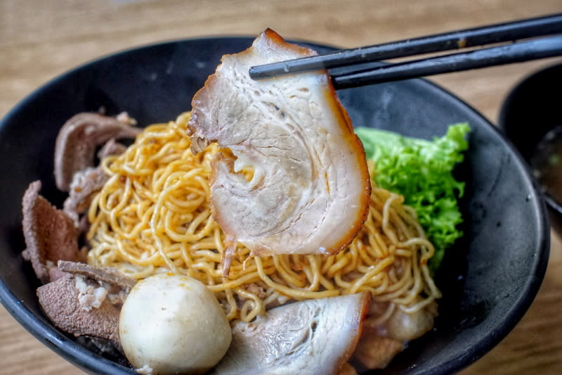 Lifting piece of chashu with chopsticks