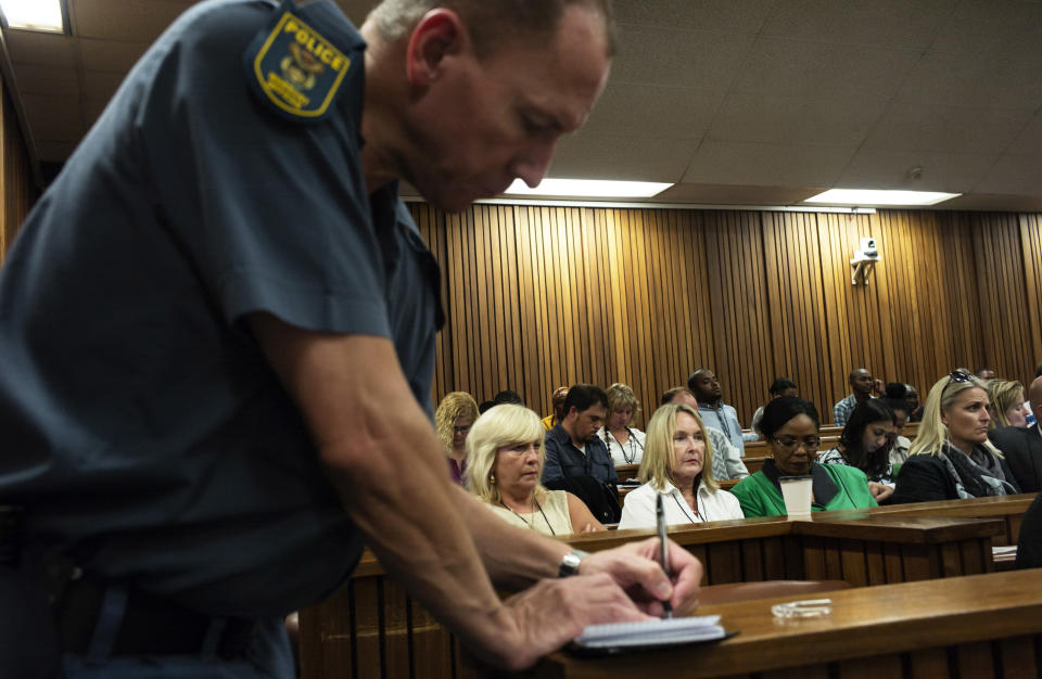 June Steenkamp, centre, the mother of Reeva Steenkamp, sits inside the court in Pretoria, South Africa, Tuesday, March 18, 2014. Police photographs of the blood-spattered scene where Oscar Pistorius shot dead his girlfriend indicate that evidence was moved around in violation of procedure during the investigation of the killing, the athlete's chief defense lawyer said Tuesday. (AP Photo/Marco Longari, Pool)