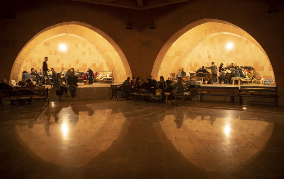 People take refuge in a bomb shelter in Stepanakert, the self-proclaimed Republic of Nagorno-Karabakh, Azerbaijan, Tuesday, Oct. 6, 2020. Armenia accused Azerbaijan of firing missiles into the capital of the separatist territory of Nagorno-Karabakh, while Azerbaijan said several of its towns and its second-largest city were attacked. (AP Photo/Dmitri Lovetsky)