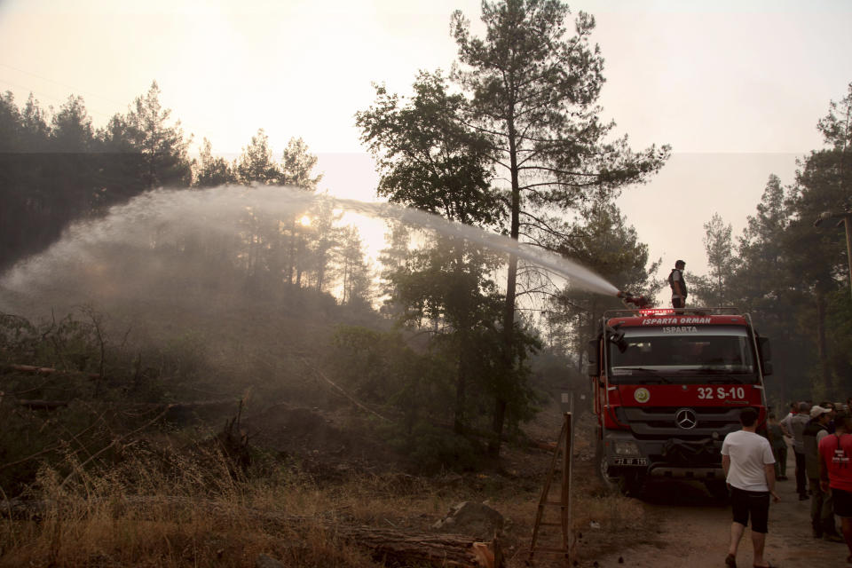 Firefighters work to extinguish a fire in the Bordubet region, near Marmaris, western Turkey, Thursday, June 23, 2022. Water-dropping aircraft from Azerbaijan and Qatar on Friday joined the fight against a wind-stoked wildfire that burned for a fourth day near a popular resort in southwestern Turkey. Turkey's forestry minister meanwhile, said the fire may be close to being contained but said the wind still posed a risk. (AP Photo)