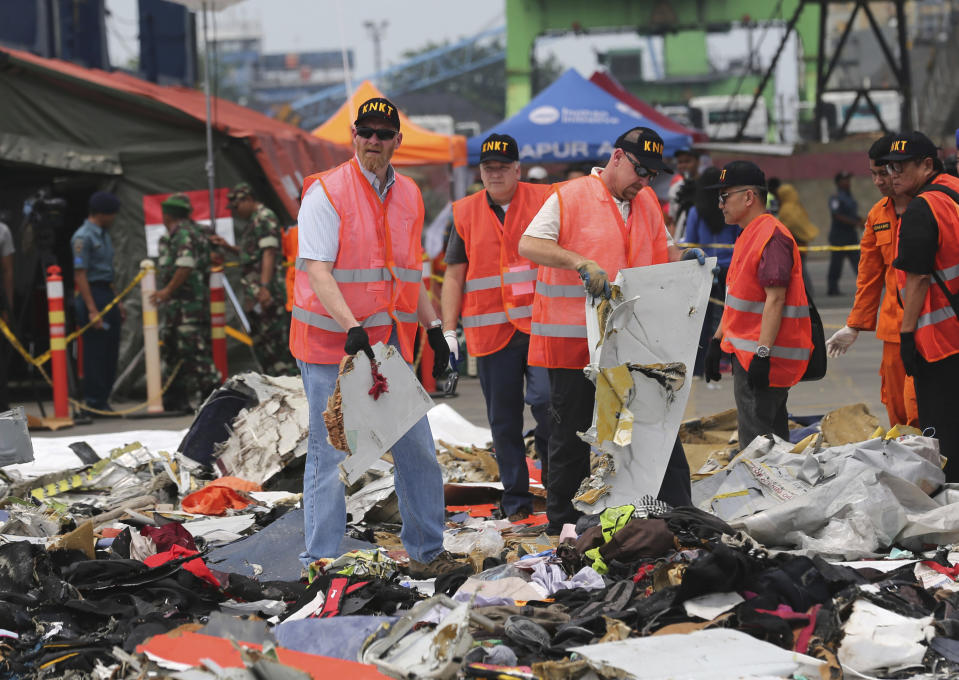 U.S. investigators examine parts recovered from the crash of a Lion Air jet at Tanjung Priok Port in Jakarta, Indonesia, Nov. 1, 2018. Lion Air flight 610, a Boeing 737 Max, crashed minutes after takeoff on Oct. 29, 2018. U.S. prosecutors and victims' families are waiting for Boeing to decide whether to accept a plea deal that would settle a criminal charge that the aerospace giant misled regulators who approved the 737 Max before two of the jetliners crashed in Indonesia and Ethiopia. (AP Photo/Tatan Syuflana, File)