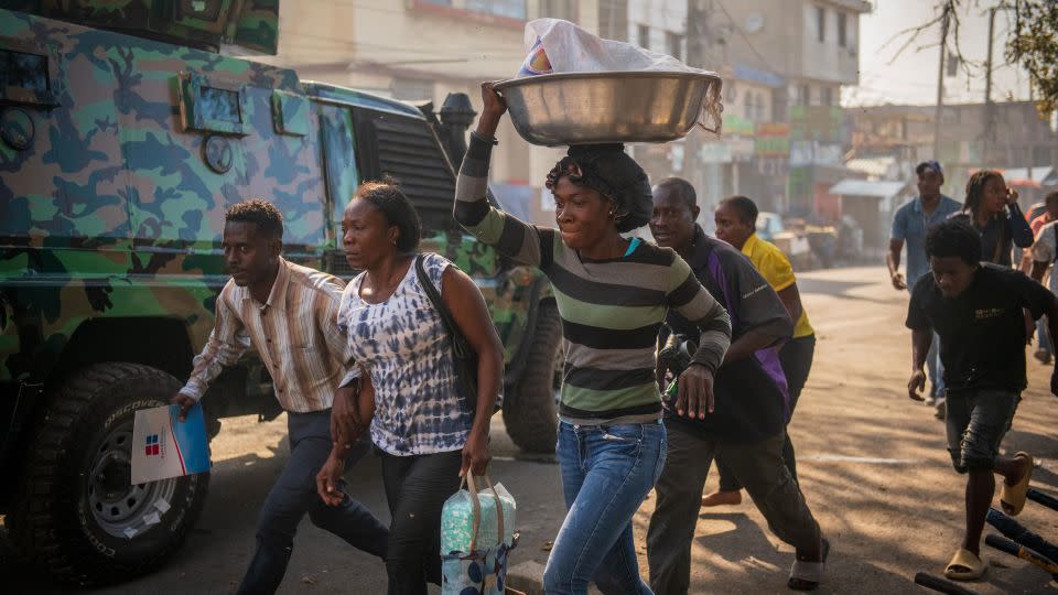 People run down a street in Port-au-Prince, Haiti, on February 29. - Johnson Sabin/EPA-EFE/Shutterstock