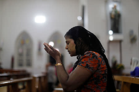 A Catholic woman prays at St. Anthony church at the eve of the mass of Pope Francis in Yangon, Myanmar November 28, 2017. REUTERS/Jorge Silva