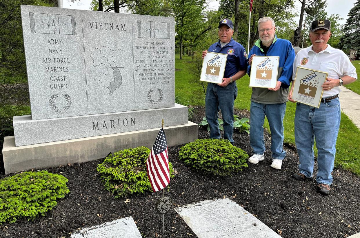 Marion County residents, from left, Randy Drazba, Terry Cline, and Frank Hickman display awards from the Houston International Film Festival for the video Cline wrote, directed, and produced to support and promote the Marion County Military Banner Campaign. They received gold Remi Awards for earning the top spot in the charitable/non-profit category at the 56th annual film festival. The photograph was taken at the Vietnam War monument in Veterans Memorial Park on Delaware Avenue in Marion. Both Drazba and Hickman are Vietnam veterans.