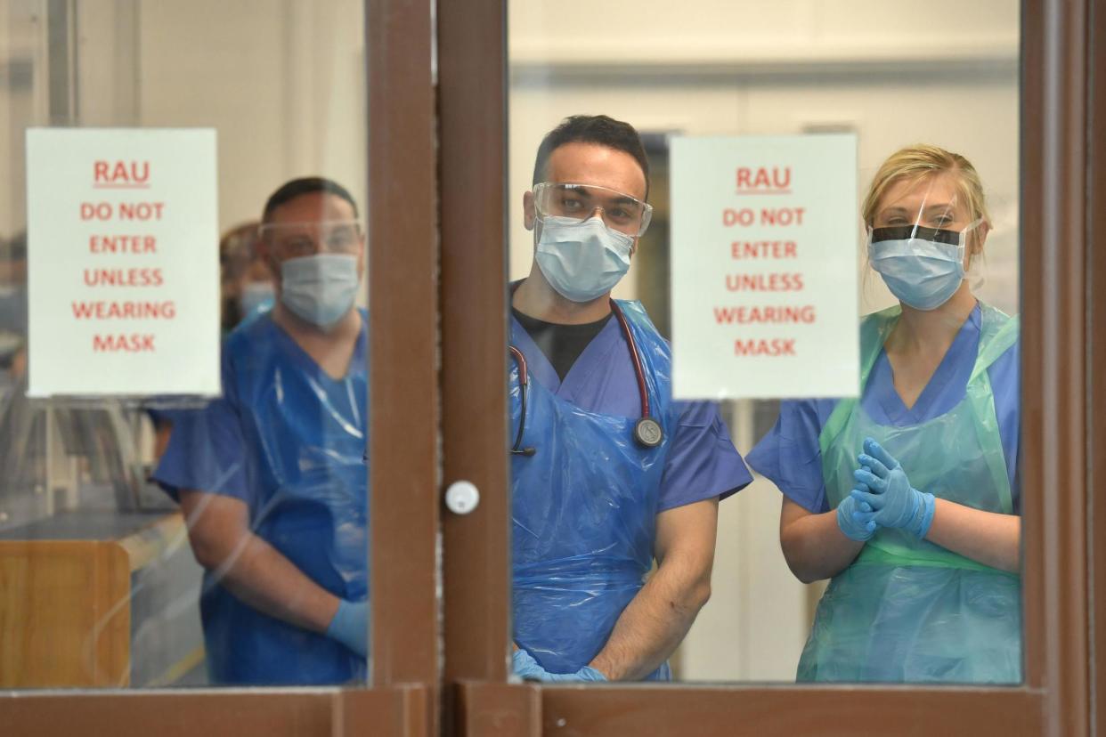 A file photo of doctors wearing personal protective equipment at a hospital: PA