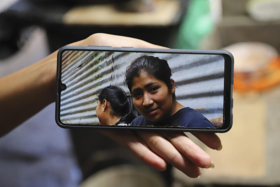 Un familiar muestra en un celular una foto de Juana Guadalupe Recinos, que fue detenida el año pasado durante la guerra del gobierno contra las pandillas, en Santa Ana, El Salvador, el 31 de enero de 2024. La policía detuvo a Recinos por "agrupación ilícita" cuando se dirigía al trabajo, dejando a sus dos hijos sin madre durante más de un año. (AP Foto/Salvador Melendez)