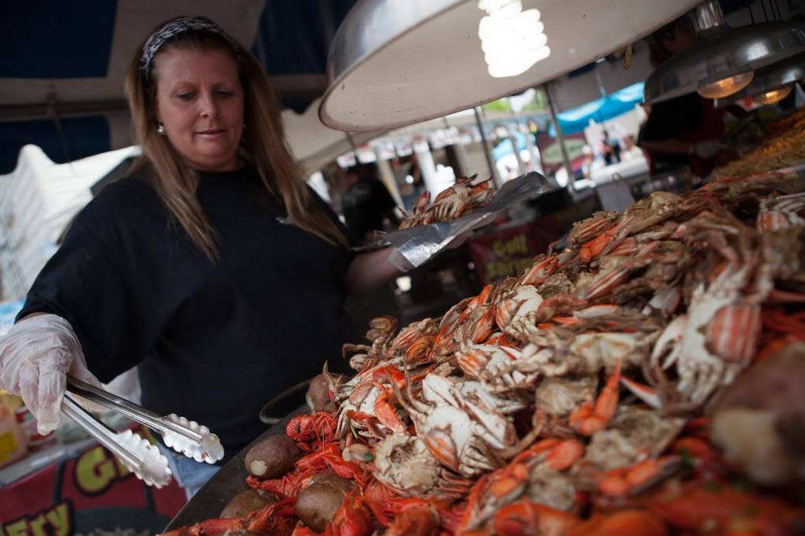 Bridgette Singletary of the Pilot House serves up crab plates Saturday. The Little River Blue Crab Festival crowds the narrow streets of the waterfront with people from around the region looking for some great food, live music and a huge selection of vendors. By Matt Silfer for The Sun News.