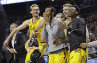 FILE - UMBC players celebrate a teammate's basket during the second half against Virginia in a first-round game in the NCAA men's college basketball tournament in Charlotte, N.C., March 16, 2018. Five years ago Thursday a tiny school few had ever heard of — and virtually no one gave an ounce of a chance to win — pulled off the biggest upset in tournament history as University of Maryland-Baltimore County knocked off the tournament’s top overall seed, elevating March Madness to a whole new level. (AP Photo/Gerry Broome, File)
