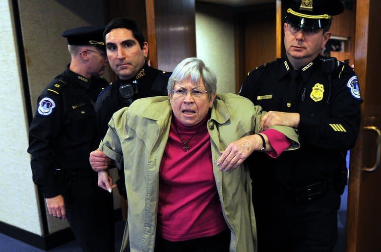 Police remove an anti-war protester as John Brennan, US President Barack Obama's pick to lead the CIA, arrives to testify before lawmakers on February 7, 2013