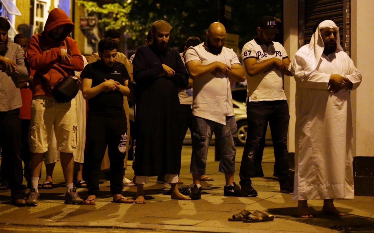 Muslims pray on a sidewalk in the Finsbury Park area of north London  - AFP