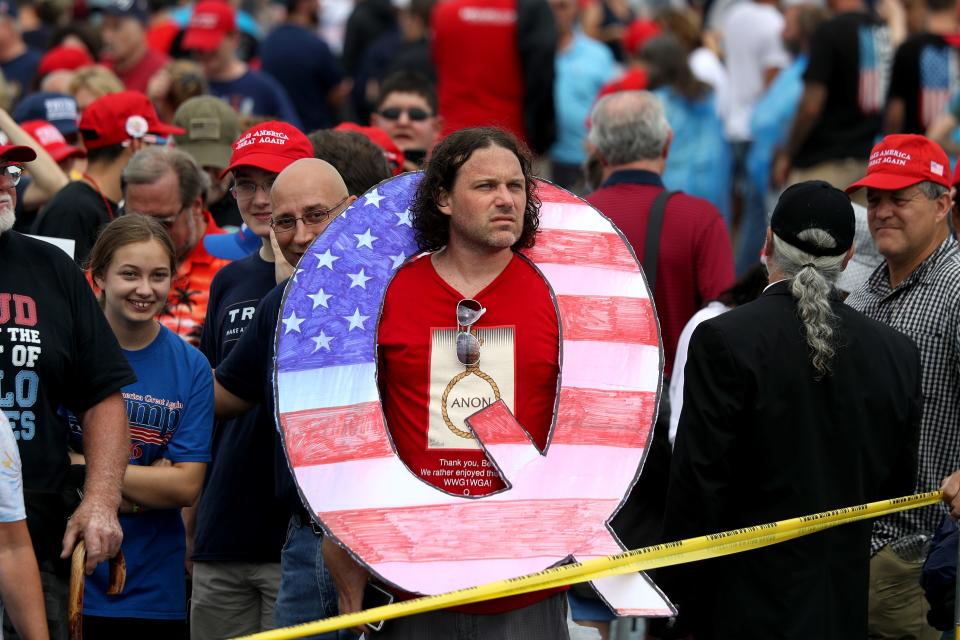 David Reinert holds a large "Q" sign while waiting in line on to see President Donald J. Trump at his rally Aug. 2, 2018, at the Mohegan Sun Arena at Casey Plaza in Wilkes Barre, Pa. "Q" represents QAnon, a conspiracy theory group that has been seen at recent rallies.