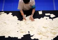 An election officer counts votes at a ballot counting centre for Japan's upper house election in Tokyo