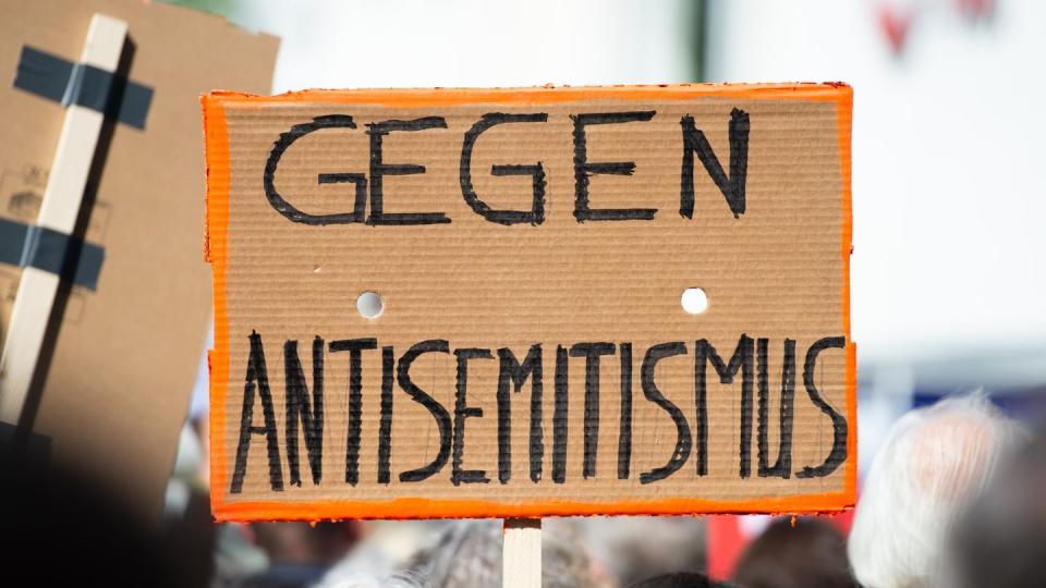 Bei einer Demo wird ein Schild gegen Antisemitismus in die Höhe gehalten. Die Erfassung antisemitischer Straftaten soll verbessert werden. (Bild: dpa)