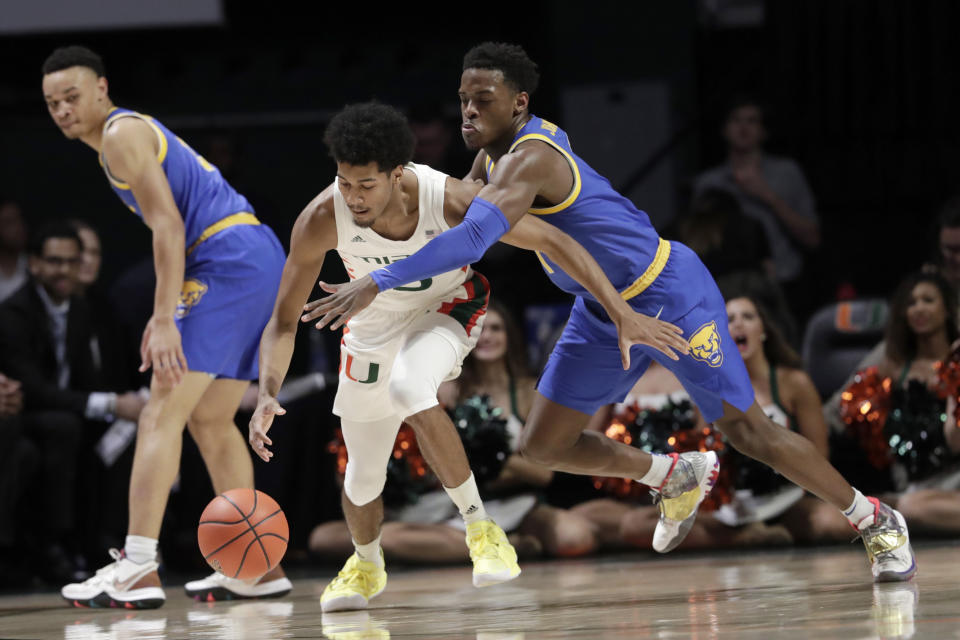 Pittsburgh guard Xavier Johnson, right, defends against Miami guard Harlond Beverly during the first half of an NCAA college basketball game, Sunday, Jan. 12, 2020, in Coral Gables, Fla. (AP Photo/Lynne Sladky)