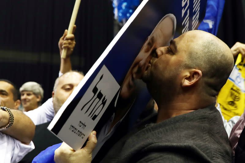 A supporter kisses a poster depicting Israeli Prime Ministers Benjamin Netanyahu as results of the exit polls in Israel's elections are announced at Netanyahu's Likud party headquarters in Tel Aviv