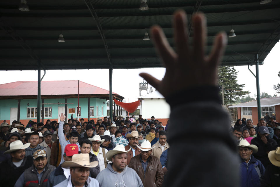 Indigenous Tzotzil men meet during the day of a non-binding national referendum on whether Mexican ex-presidents should be tried for any illegal acts during their time in office, at the Corazon de Maria community, in Chiapas state, Mexico, Sunday, August 1, 2021. (AP Photo/Emilio Espejel)