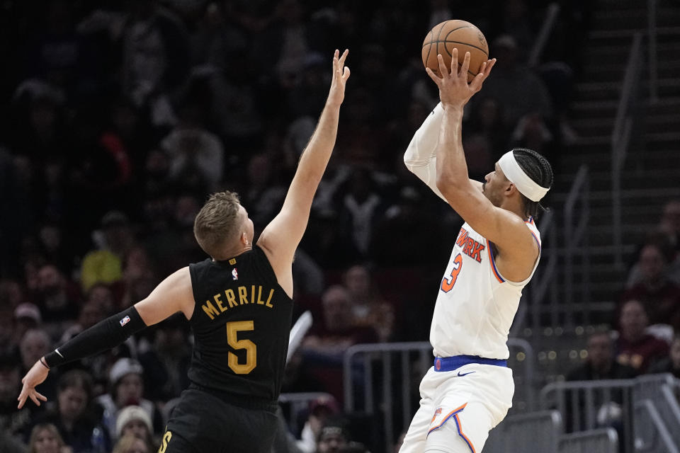 New York Knicks guard Josh Hart shoots over Cleveland Cavaliers guard Sam Merrill (5) in the second half of an NBA basketball game, Sunday, March 3, 2024, in Cleveland. (AP Photo/Sue Ogrocki)