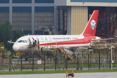 Workers inspect a Sichuan Airlines aircraft that made an emergency landing after a windshield on the cockpit broke off, at an airport in Chengdu, Sichuan province, China May 14, 2018. Picture taken May 14, 2018. REUTERS/Stringer