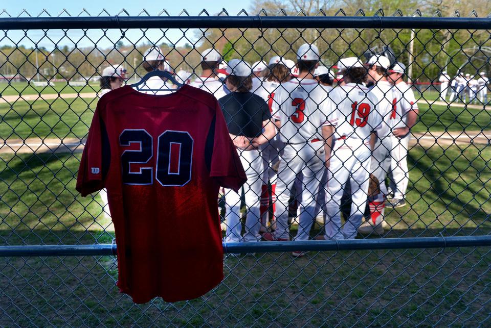 The Holliston High School baseball team hangs a No. 20 jersey in honor of Holliston alum Corey Ciarcello (2009) who died in February, here at their game against Dover-Sherborn on May 11.