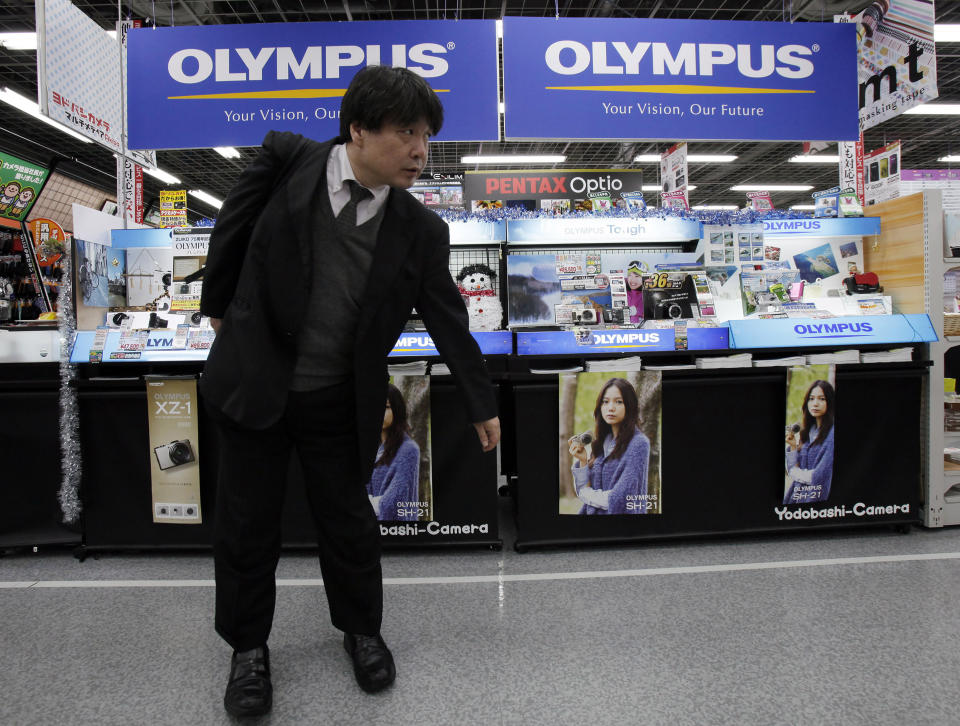 FILE - A shopper walks by a sales counter of Olympus cameras at a store in Tokyo on Dec. 8, 2011. Japanese medical equipment maker Olympus said Friday, Oct. 21, 2022 it has named as its chief executive Stefan Kaufmann, a German who has worked for two decades at the manufacturer once known for old-style photographic cameras. (AP Photo/Koji Sasahara, File)